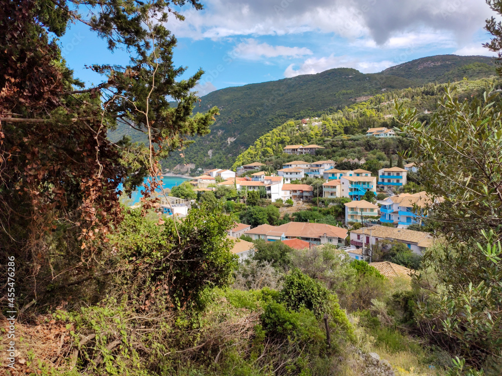 Picturesque traditional greek village on green hills near sea shore on Lefkada island, Greece. Travel Europe in summer