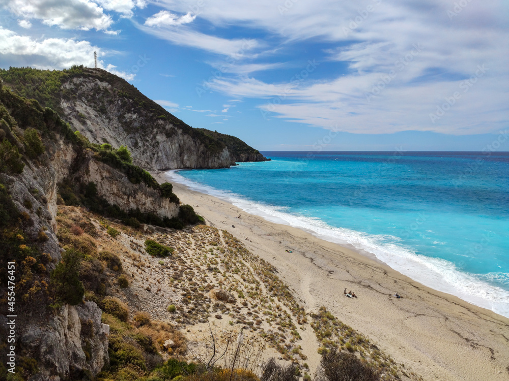 Mylos sandy beach with azure vibrant stormy waves on coast of Lefkada island in Greece. Summer nature vacation travel to Ionian Sea Mylos sandy beach with azure vibrant stormy waves on coast of Lefkada island in Greece. Summer nature vacation travel to Ionian Sea
