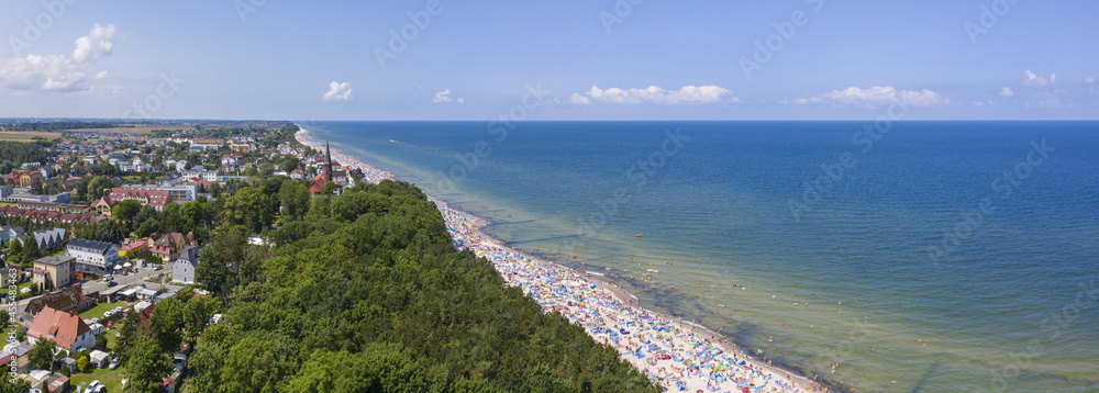 Morze bałtyckie, w tle miejscowość Sarbinowo i zatłoczona plaża - obrazy, fototapety, plakaty 