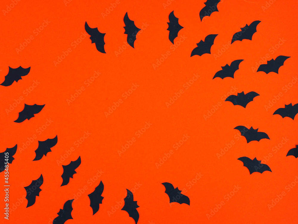 Silhouette of bats circling on orange. Background for Halloween party flyers. Place for your text. Flat layout.