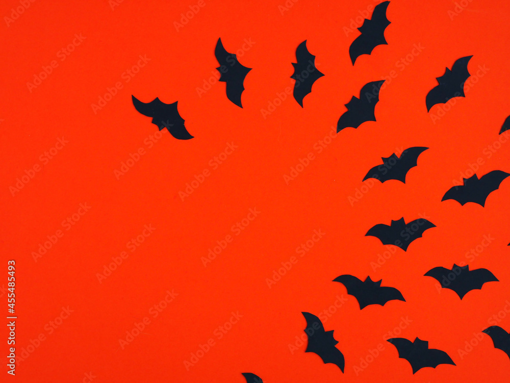 Silhouette of bats circling on orange. Background for Halloween party flyers. Place for your text. Flat layout.