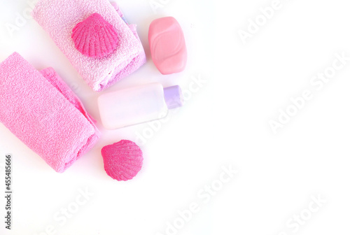 Spa set. Towel, soap, washcloth, care products, bath bombs in pink and pale purple. Place for your text. Flat layout.