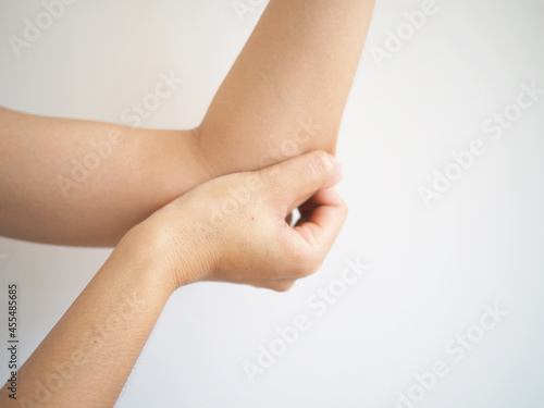 Acute pain in the elbow of a woman. woman holding elbow pain point on white background.