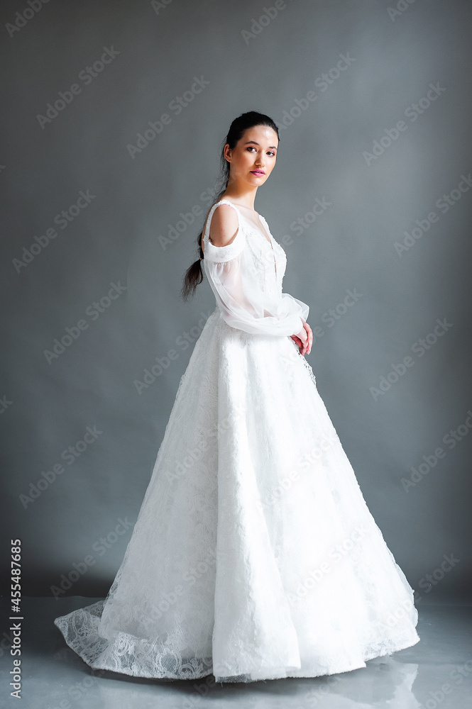 Fototapeta premium Smiling young woman posing in a wedding dress