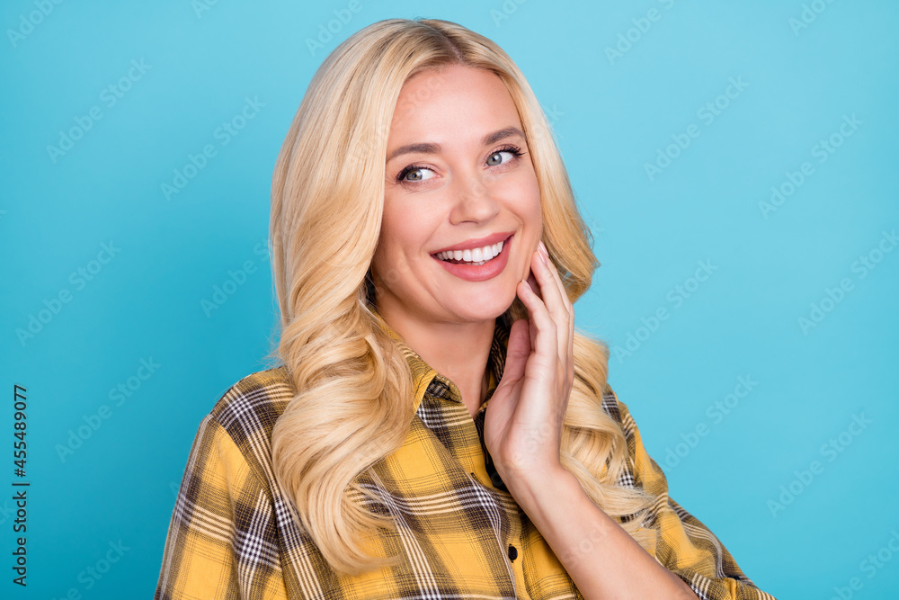 Portrait of attractive cheerful wavy-haired woman wearing checked shirt enjoying good news isolated over bright blue color background Portrait of attractive cheerful wavy-haired woman wearing checked shirt enjoying good news isolated over bright blue color background