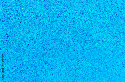 Rubber crumb artificial coating of modern multifunctional sports ground. Safe soft anti-slip floor for playground. Blue textured background. photo