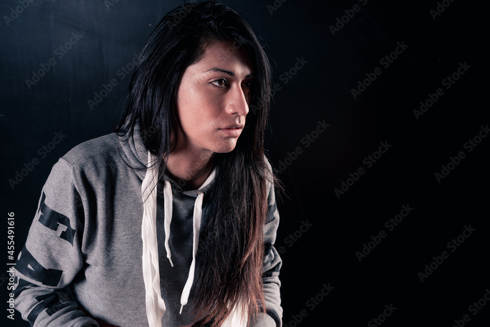 Fototapeta premium Beautiful woman sitting on a bench thinking and finishing training. Isolated on black background.