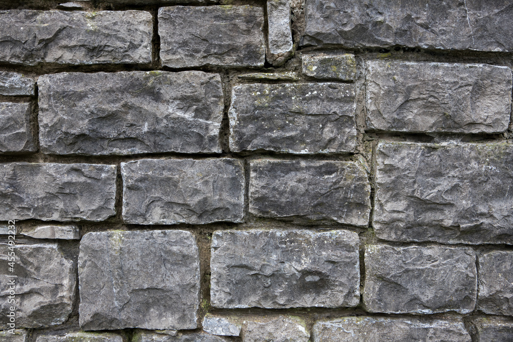 Textured stone wall background. Square patterns on an old grey wall Textured stone wall background. Square patterns on an old grey wall