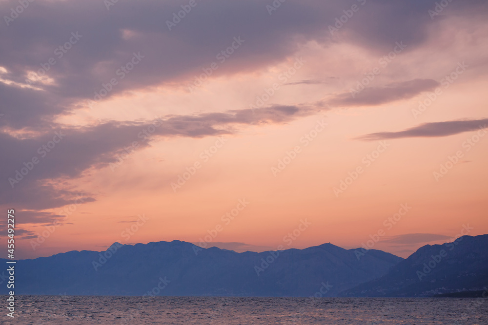 Idyllic nature landscape, mountain range on the horizon line behind the water at the sunset beautiful colors, travel and holidays concept