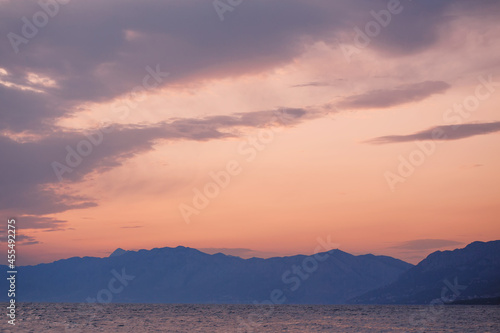 Idyllic nature landscape  mountain range on the horizon line behind the water at the sunset beautiful colors  travel and holidays concept