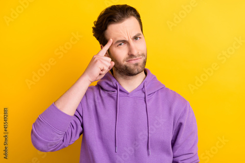 Photo of young man finger touch head accuse blame stupid idiot isolated over yellow color background