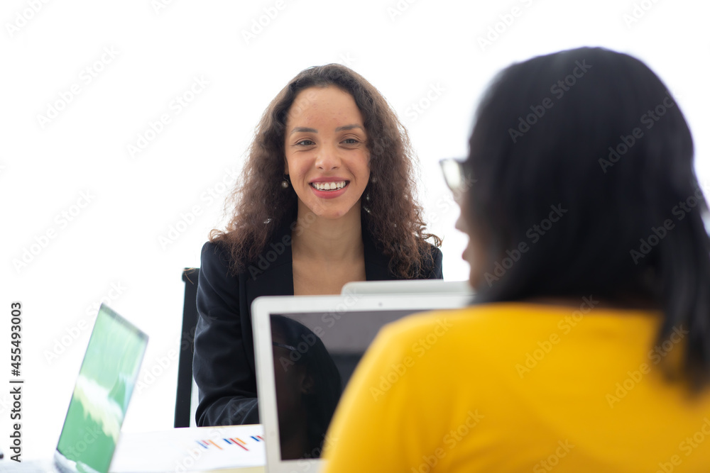 Beautiful african american and hispanic businesswoman working on laptop computer together at modern home office. Beautiful african american and hispanic businesswoman working on laptop computer together at modern home office.