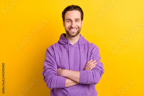 Photo of young cheerful man happy positive smile folded hands glad isolated over yellow color background