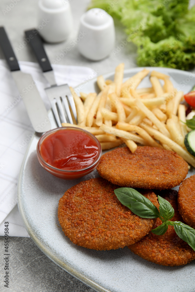 Delicious fried breaded cutlets with garnish on grey table, closeup