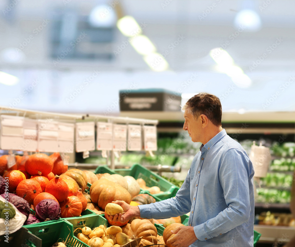 Fototapeta premium Senior Man Choosing groceries, vegetables, fruits in the supermarket