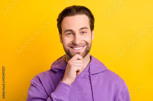 Photo of smart intelligent guy finger chin toothy beaming smile wear purple hoodie isolated yellow color background