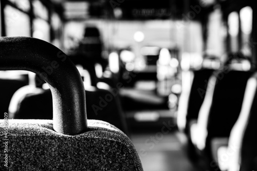 Focus on headrest of empty metro bus with the aisle to the front cleared