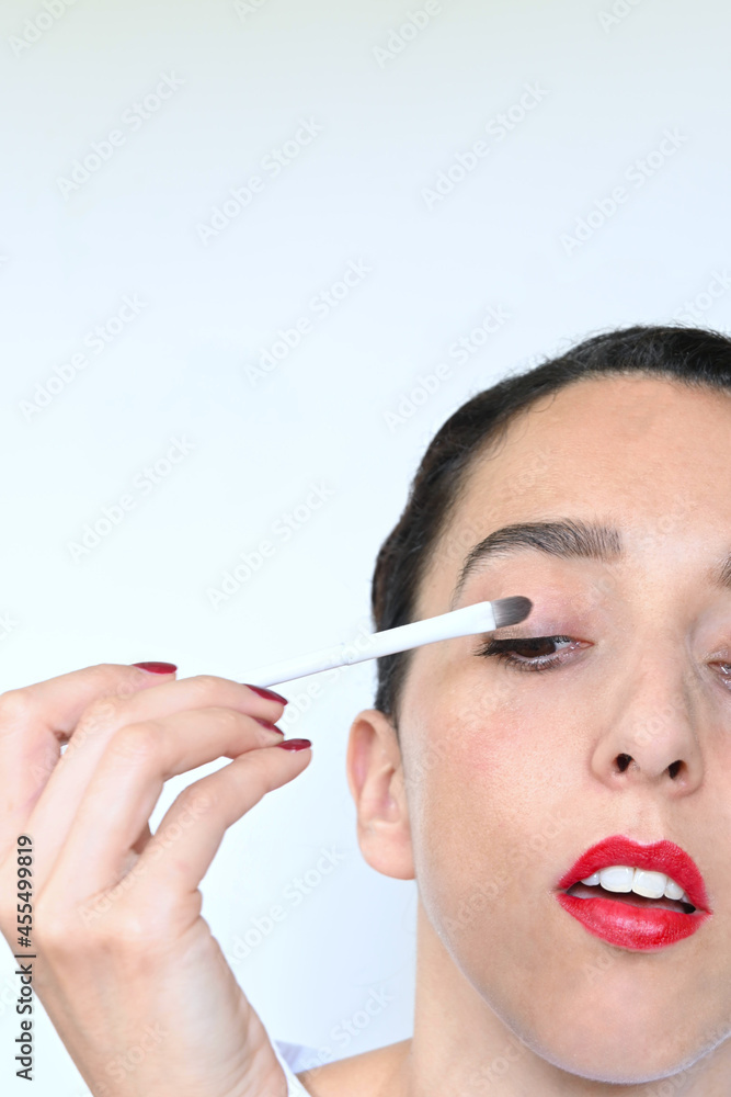 Young latina woman's face putting on eye shadow