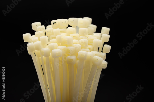 White nylon cable tie or zip tie on black background photo