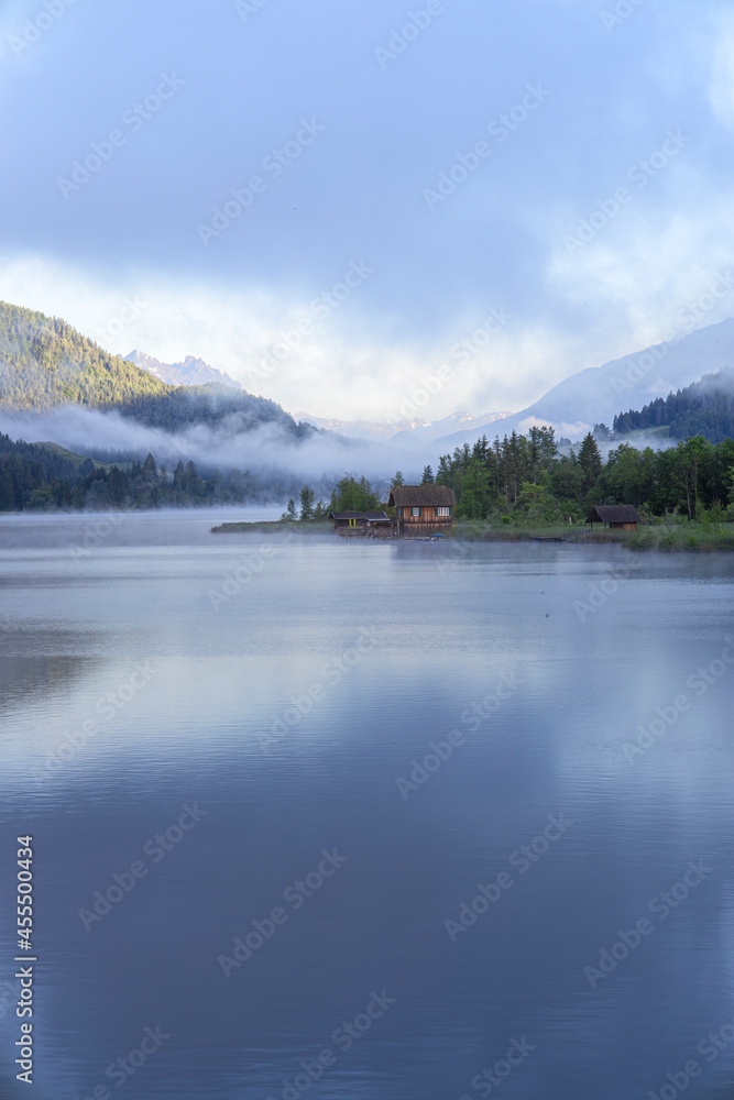 Tranquil Austrian landscape with lake and mountains in the summer morning. 