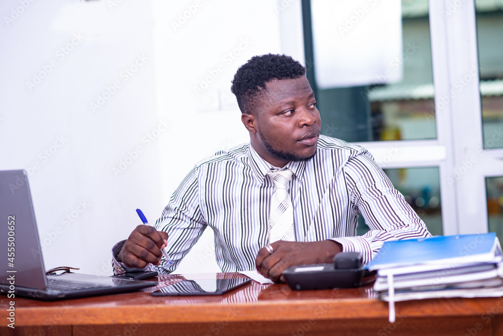 portrait of a young businessman working on laptop in the office portrait of a young businessman working on laptop in the office