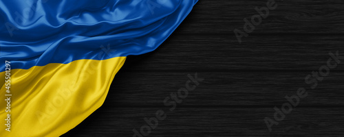 Close Up of Ukraine flag on the black wooden background 3D render photo