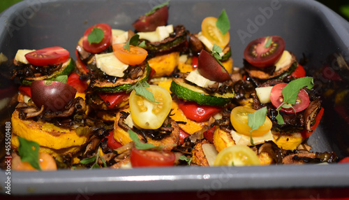 Foto Gemüsegericht mit Zucchini, Tomaten, Basilikum Oregano in Türmchen, veganes Esse
