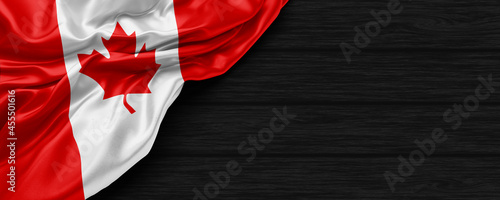 Close Up of Canada flag on the black wooden background 3D render