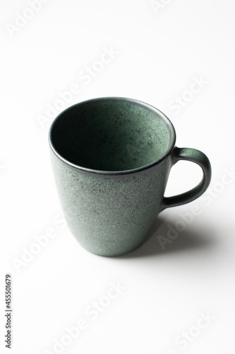Vertical of green pottery green coffee cup isolated on white 