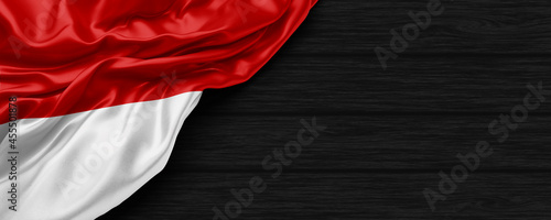 Close Up of Indonesia flag on the black wooden background 3D render