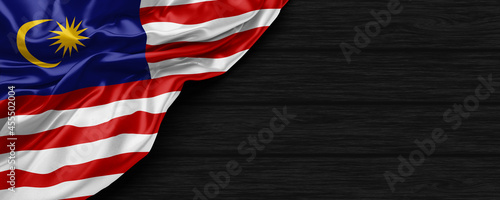 Close Up of Malaysia flag on the black wooden background 3D render