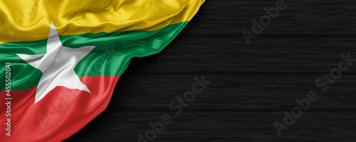Fotografie Close Up of Myanmar flag on the black wooden background 3D render