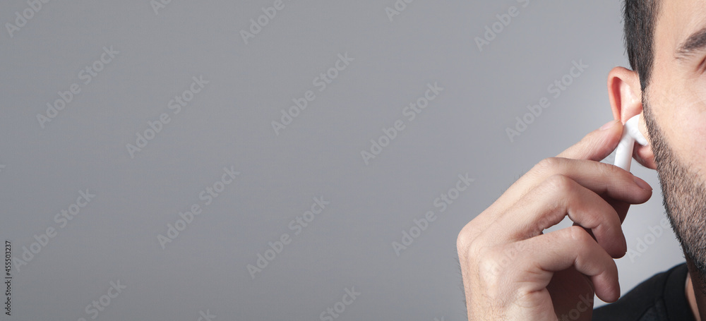 Caucasian man wearing white wireless earphone.