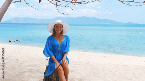 Young beautiful women in the blue tunic on the sunny tropical beach photo