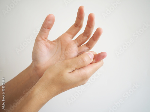woman touching her injured finger on white background  health care concept.
