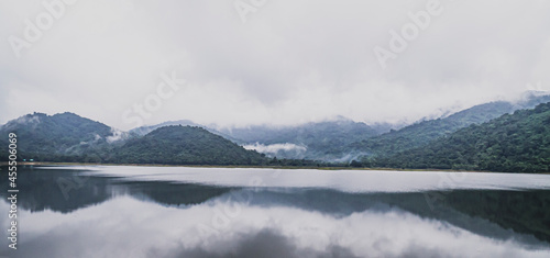 Panorama view of  mountains Lake with tropical trees forest . Beautiful A Calm Lake With Mountain ranges on background . Wonderful atmospheric landscape