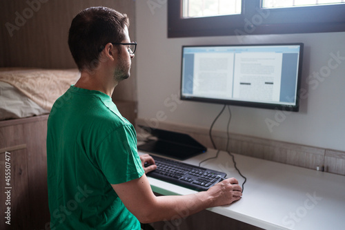 Editor redacting text on computer monitor at home