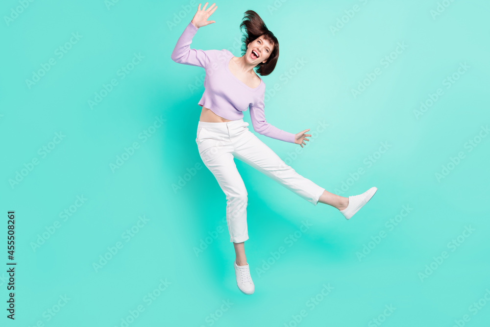 Full length body size photo woman childish careless jumping up isolated bright teal color background Full length body size photo woman childish careless jumping up isolated bright teal color background