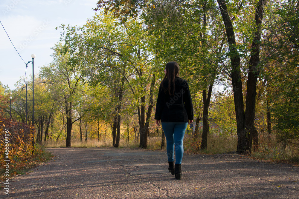 Faceless woman walking in park in autumn Faceless woman walking in park in autumn
