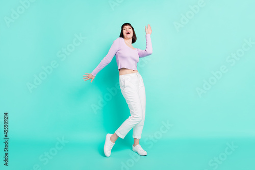 Full length body size photo woman in casual outfit dancing at party laughing overjoyed isolated vivid teal color background © deagreez