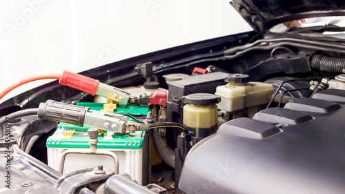 A technician is checking the car battery for availability.; 