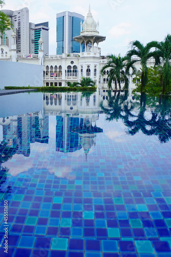 The beautiful swimming pool with a building scenery of Kuala Lumpur and reflection on the pool.  © peacefoo