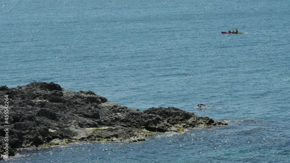 active people during summer leisure activity of rowing kayak canoeing and diving during sport active lifestyle in blue sea near rocky island active people during summer leisure activity of rowing kayak canoeing and diving during sport active lifestyle in blue sea near rocky island
