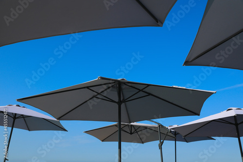 Beach umbrellas against blue sky on sunny day