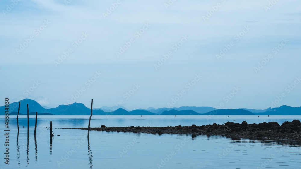 Peaceful misty mountain layer and faraway local fisherman. Koh Samui Island, Thailand. Minimal panorama background with copy space.
