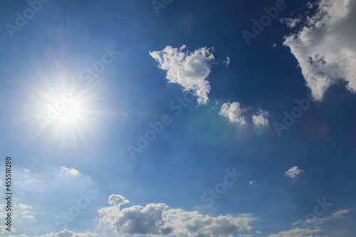 Sunbeams with  white clouds on blue sky background in summer