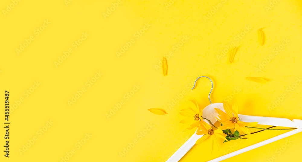 Autumn shopping creative banner. Fall shopping, autumn sale, promotion, discount. White hanger with flowers on a bright yellow background. Flat lay, copy space