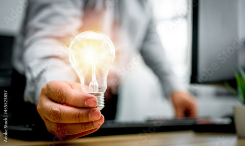 Businessman holding lightbulb and feeling happy by new innovation and ideas for success business panels. Concept of innovation creative technology ideas for Business solution