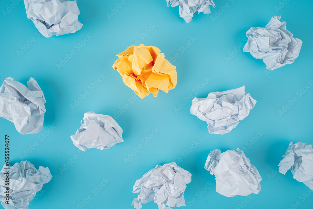 Crumpled paper balls, waste and recycling concept on blue background. Inspiration concept.