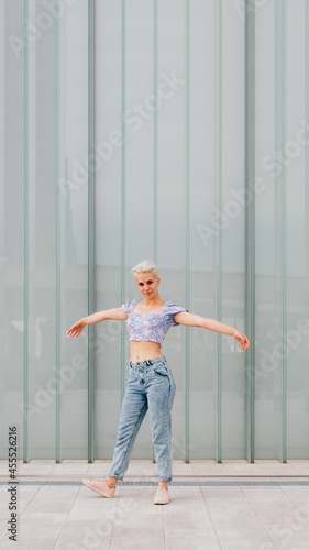 Fototapeta Naklejka Na Ścianę i Meble -  Young caucasian woman outdoor dancing celebrating success feeling free - advertising copyspace